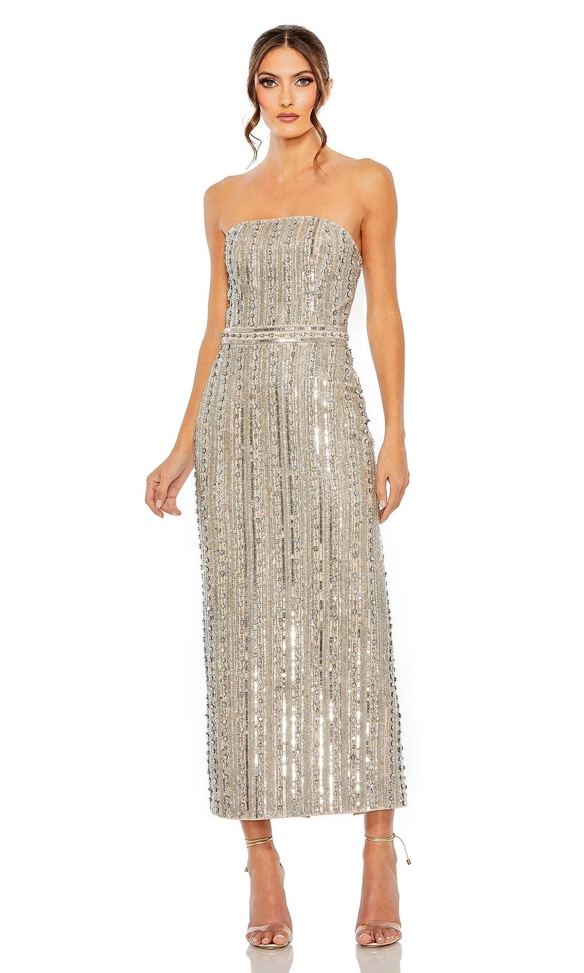 A woman wears the Mac Duggal 93831 strapless midi formal dress, featuring silver sequins and vertical stripes, paired with strappy high-heeled sandals for a striking formal look.